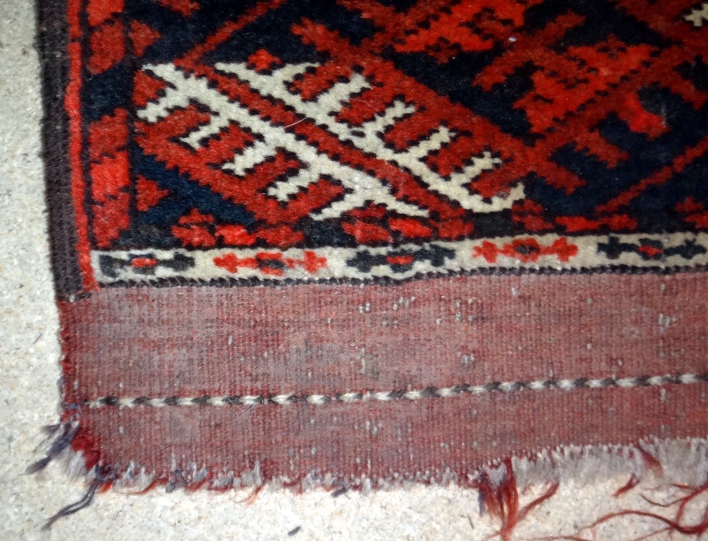 A Tekke Turkmen rug, the madder field with two columns of seven guls, supporting crosses, - Image 5 of 7