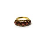 A late Victorian, 18ct gold and garnet set five stone ring, mounted with a row of graduated garnets,