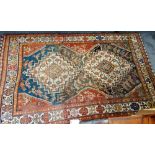 A Ghasghai rug, Persian, the brown field with two bold stepped ivory medallions supporting chickens,