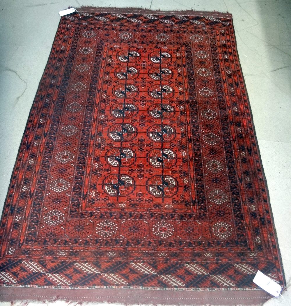 A Tekke Turkmen rug, the madder field with two columns of seven guls, supporting crosses,