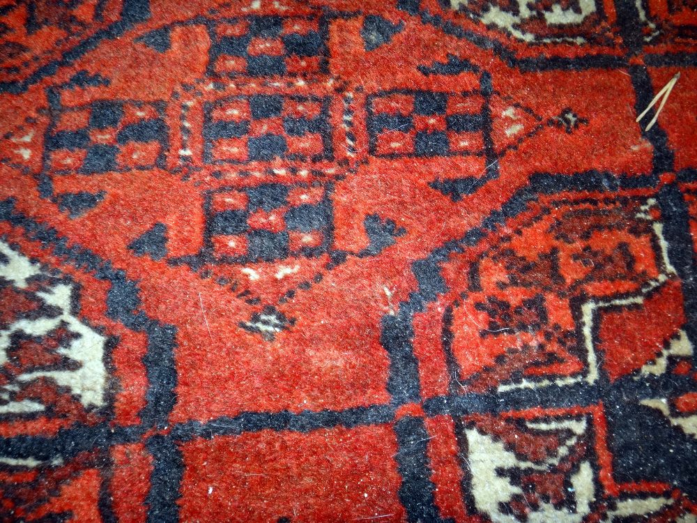 A Tekke Turkmen rug, the madder field with two columns of seven guls, supporting crosses, - Image 3 of 7