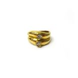 A gold and diamond set ring, in a twin twistover design, mounted with two circular cut diamonds,