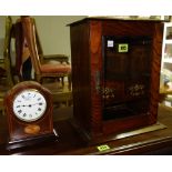 An early 20th century oak smoker's cabinet and a mantel clock.