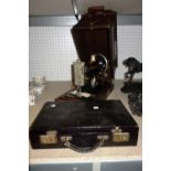 An early 20th century singer sewing machine and a small black leather case.