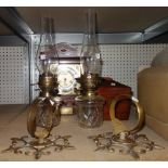 An oak cased eight day mantel clock, a pair of wall mounted oil lamps and a mahogany tea caddy (4).