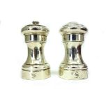 Cartier: A cased pair of sterling silver mounted capstan salt mill and shaker, 10 & 9.