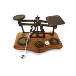 A set of brass postal scales and weights, by John Heath, Birmingham, with wooden base, 19cm wide.