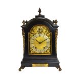 A German eight day ebonised mantel clock, late 19th century, the arch top case with foliate finials,