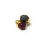 A gold, cabochon sapphire and cabochon ruby set two stone ring, in a twistover design, ring size H,