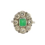 A white gold, emerald and diamond oval cluster ring,