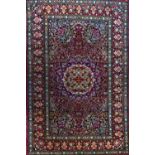 A Kerman rug, Persian, the madder field with an ivory and black roundel, matching spandrels,