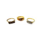 A gold and diamond three stone ring, mounted with a row of cushion shaped diamonds,