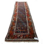 A Kazak runner, Caucasian, the dark blue field with repeating boteh design,