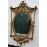 A late 19th century gilt framed mirror with acanthus mounted architectural crest over oval plate