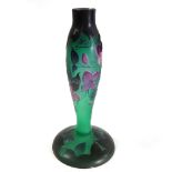 A Galle style glass lamp base relief decorated with purple blooms against a green ground on a wide