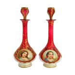 A pair of Bohemian cranberry glass and enamel overlay decanters and stoppers, 19th century,