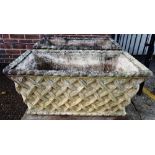 A pair of composite stone planters, each with lattice work tapering rectangular bodies,