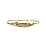 A gold and diamond set bracelet, the front in a curved panel shaped pierced geometric design,