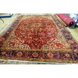 An Heriz carpet, Persian, the dark madder field with a bold central rosette medallion,