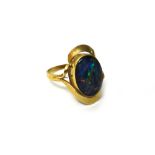 A gold ring, mounted with an oval opal doublet, between openwork shoulders, ring size R and a half.