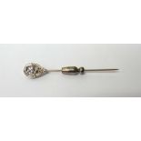 A diamond set stick pin, in a drop shaped design, mounted with a cushion shaped diamond.