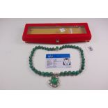 A necklace composed of green corundum faceted beads, 10-13mm, suspending a leaf carved panel,