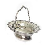 A shaped oval silver sweetmeat basket, S W Smith & Co, Birmingham 1910, with swing handle,