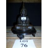 An antique bronze Buddha on a wooden sta