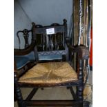 A 19c oak elbow chair with worn rush sea