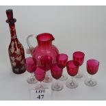 A set of eight cranberry glass wines and a jug;