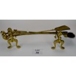 A set of four Edwardian brass fire-irons with claw and ball handles together with a matching pair