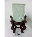 A Chinese Celadon glazed brush pot decorated with figural scenes at play in high relief;