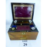 A Victorian rosewood jewellery box with fitted interior containing scent bottles and inkwell,