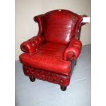 A late 20c red leather armchair complete