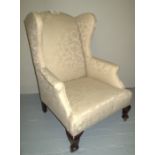 An early 20c winged armchair upholstered