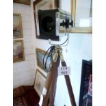 A polished Strand theatre light on a wooden and brass tripod c.