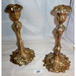 A pair of silver embossed candlesticks decorated with scrolls and vine leaves (approx 11" high)