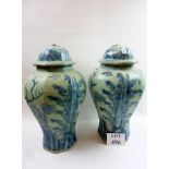 A pair of large decorative Oriental blue and white pottery vases and covers with octagonal bases