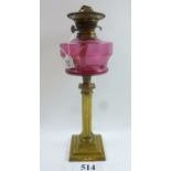 A late Victorian brass oil lamp with cranberry glass shade est: £160-£220 (AF9)