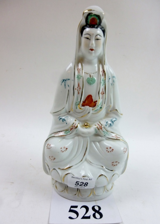 A Chinese figurine of a Guanyin seated o