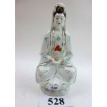 A Chinese figurine of a Guanyin seated o