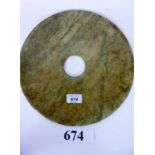 A Chinese jade bi disk, the mottled green, white and brown matrix with plain circular aperture,