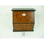 An ebonised and burr jewellery box of bureau form,