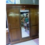 An Edwardian mahogany triple wardrobe wi