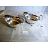 A pair of silver sauce boats with pad fe
