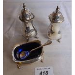 A pair of silver pepper pots and matchin