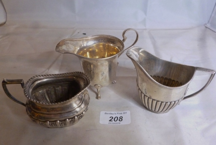 A collection of three silver cream jugs