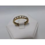 Gold full eternity ring set with white sapphires, size Q/R.