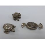 Silver pill box in the form of a wrapped sweet together with plated ones in the form of a frog and