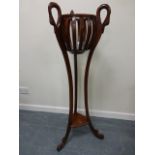 A mahogany jardiniere stand, the three decorative handles formed as swan necks, with undertier,